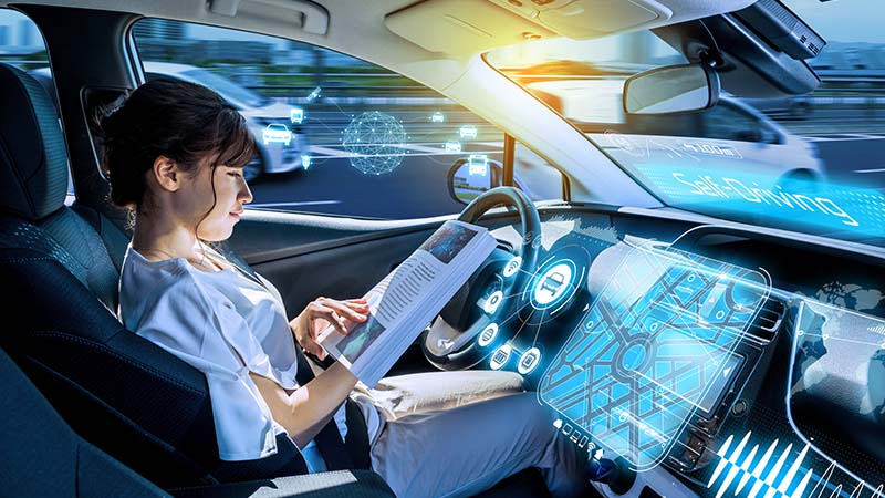 Photo of a person reading a magazine in a self-driving car